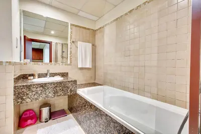 a bathroom with a tub and a sink and a mirror at Big Studio in Rimal at The Beach JBR in Dubai