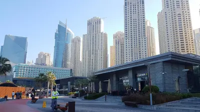 a man standing in front of a building in a city at Big Studio in Rimal at The Beach JBR in Dubai