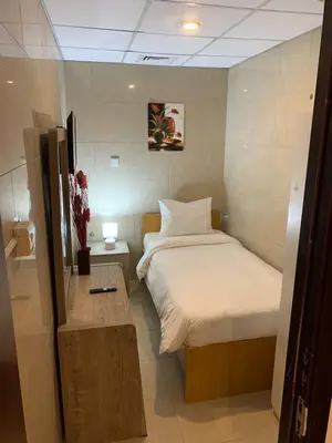 a small bedroom with a bed and a table at Small Budget Rooms for 'girls' only in Dubai, Marina in Dubai