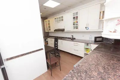 a kitchen with white cabinets and a counter top at Small Budget Rooms for 'girls' only in Dubai, Marina in Dubai