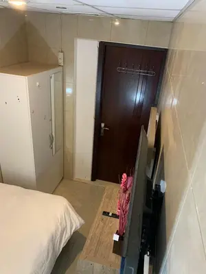 a bedroom with a bed and a brown door at Small Budget Rooms for 'girls' only in Dubai, Marina in Dubai