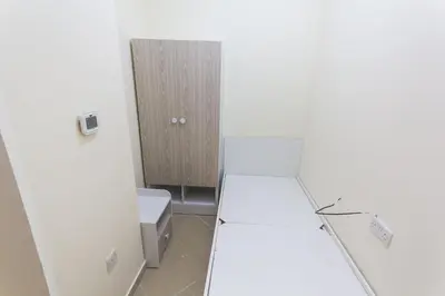 a room with white walls and a toilet and a cabinet at Small Budget Rooms for 'girls' only in Dubai, Marina in Dubai