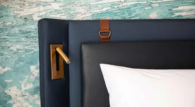 a bed with a black head board and a white pillow at Hotel Indigo Dubai Downtown by IHG in Dubai