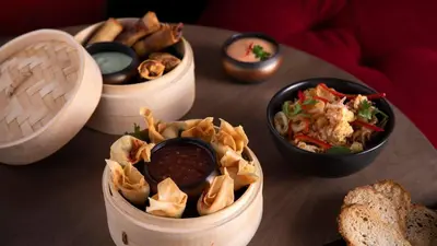 a table with three bowls of food and bread at Hotel Indigo Dubai Downtown by IHG in Dubai