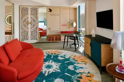 a living room with a red chair and a table at Hotel Indigo Dubai Downtown by IHG in Dubai