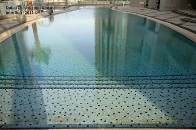a large swimming pool with blue water in a building at Luton Vacation Homes - The Marina Torch - Sea view - 64AB07 in Dubai