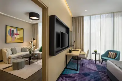 a living room with a television and a living room with a couch at Millennium Al Barsha in Dubai