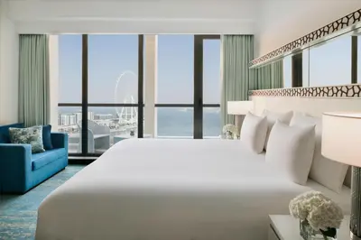 a bedroom with a large bed and a blue couch at JA Ocean View Hotel, Jumeirah Beach Dubai in Dubai