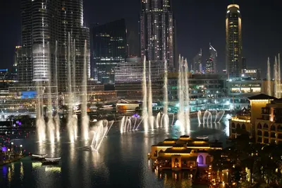 a group of water fountains in a city at night at Elite Royal Apartment - Full Bujr Khalifa & Fountain View - Senator - 2 bedrooms & 1 open bedroom without partition in Dubai