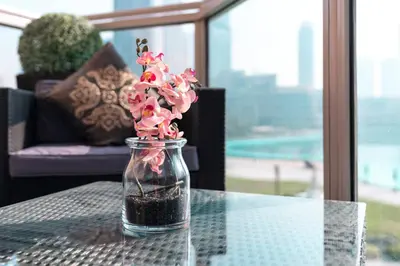 a glass jar filled with pink flowers on a table at Elite Royal Apartment - Full Bujr Khalifa & Fountain View - Senator - 2 bedrooms & 1 open bedroom without partition in Dubai