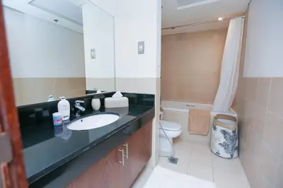 a bathroom with a sink and a toilet and a mirror at Prime Retreats - Downtown Dubai in Dubai