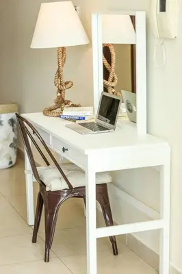 a white desk with a laptop and a lamp on it at Prime Retreats - Downtown Dubai in Dubai