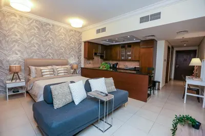 a bedroom with a bed and a blue couch at Prime Retreats - Downtown Dubai in Dubai