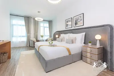 a bedroom with a large bed and a desk at Westminster Burj Residences in Dubai