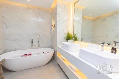 a white bathroom with two sinks and a tub at Westminster Burj Residences in Dubai