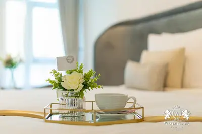a vase of flowers and a cup on a table at Westminster Burj Residences in Dubai