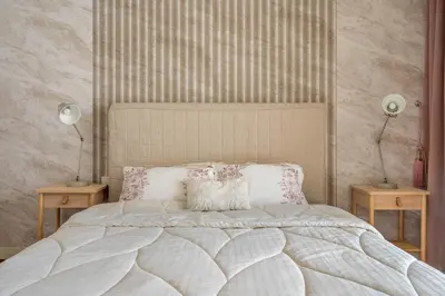 a bedroom with a bed with two lamps and two tables at City walk apartment Specter in Dubai