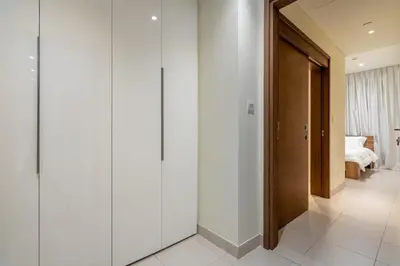 a hallway with white walls and a door to a bedroom at City walk apartment Specter in Dubai