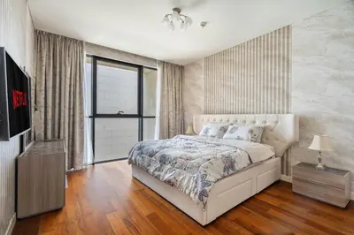 a bedroom with a white bed and a television at City walk apartment Specter in Dubai