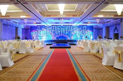 a banquet hall with white tables and chairs and a red carpet at Millennium Plaza Downtown Suites in Dubai