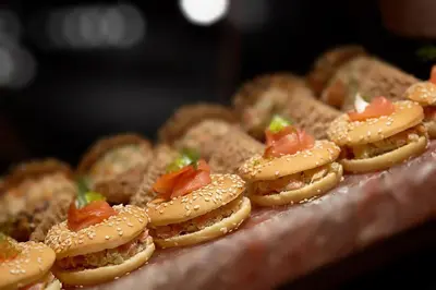 a pile of sandwiches with tomatoes on a table at Millennium Plaza Downtown Suites in Dubai