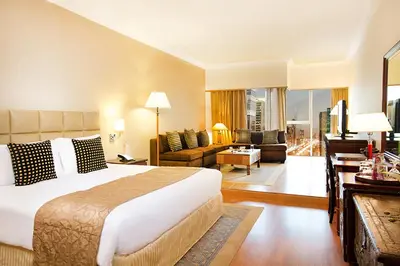 a hotel room with a bed and a living room at Millennium Plaza Downtown Suites in Dubai