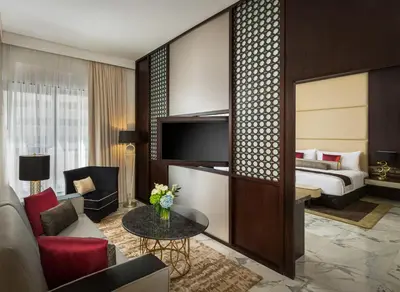 a hotel suite with a bed and a living room at Millennium Place Dubai Marina in Dubai