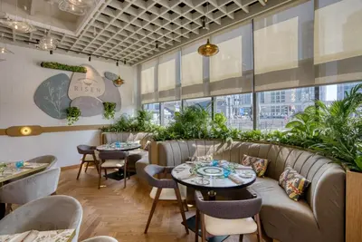 a restaurant with couches and tables and plants at Millennium Place Dubai Marina in Dubai