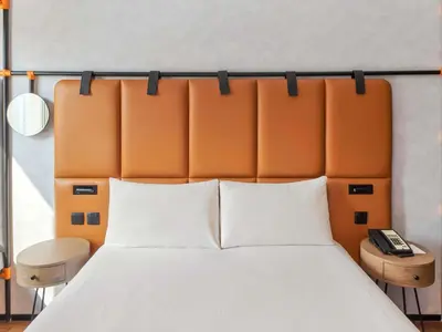 a bed with an orange headboard in a room at ibis Dubai World Trade Centre in Dubai
