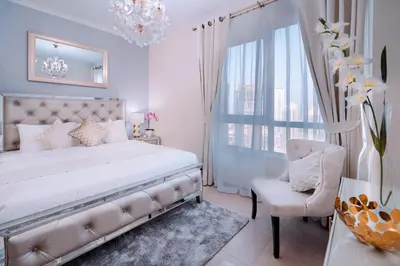 a bedroom with a bed and a chair and a window at Elite Royal Apartment - Full Burj Khalifa & Fountain View - Royal in Dubai