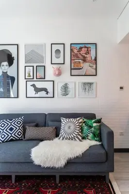 a living room with a blue couch and pictures on the wall at Wow! Super Luxury Apartment in Dubai Marina - 1BR RO in Dubai