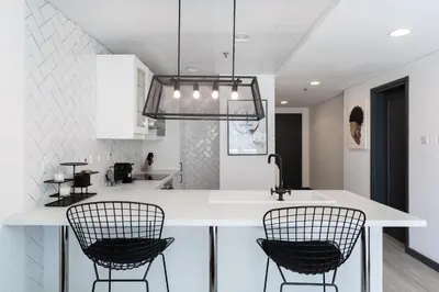 a kitchen with two chairs sitting at a counter at Wow! Super Luxury Apartment in Dubai Marina - 1BR RO in Dubai
