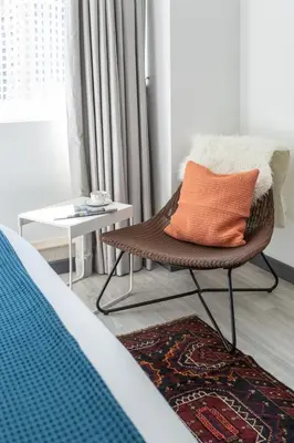a chair with an orange pillow in a room at Wow! Super Luxury Apartment in Dubai Marina - 1BR RO in Dubai