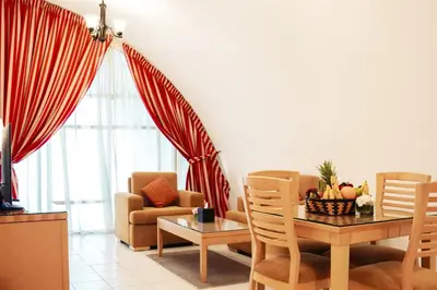 a living room with a table and a chair at Roda Al Murooj Residences in Dubai