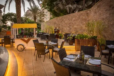 a patio with tables and chairs and a restaurant at Roda Al Murooj Residences in Dubai