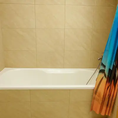 a bath tub in a bathroom with a blue shower curtain at comfortable Rooms For Girls in Marina Dubai, the best offer in Dubai