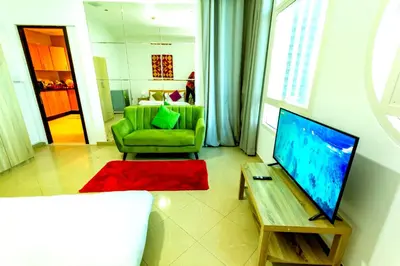 a living room with a green couch and a television at comfortable Rooms For Girls in Marina Dubai, the best offer in Dubai