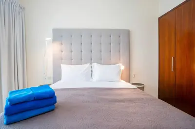 a bedroom with a large bed with blue pillows on it at New Arabian -Panorama 2 BR Full Golf course View in Dubai