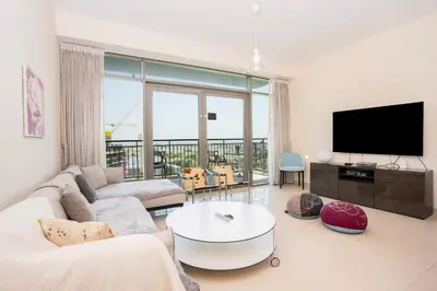 a living room with a couch and a tv at New Arabian -Panorama 2 BR Full Golf course View in Dubai