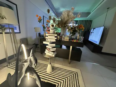 a living room with a pile of books on a table at Downtown Al Bahar Apartments in Dubai