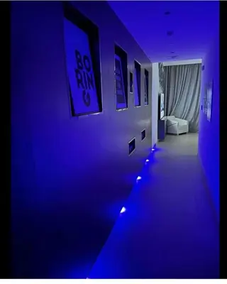 a hallway with blue lights and posters on a wall at Downtown Al Bahar Apartments in Dubai
