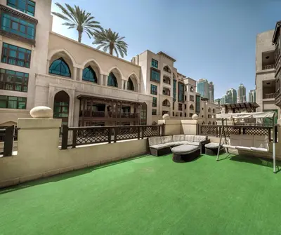 an outdoor patio with green grass in a building at Downtown Al Bahar Apartments in Dubai