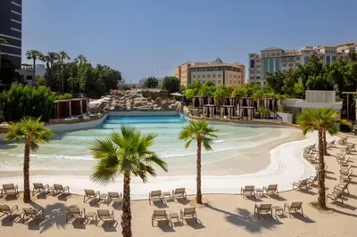 a resort with a swimming pool with chairs and palm trees at Grand Hyatt Dubai Resort & Waterpark in Dubai