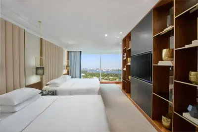 a hotel room with two beds and a large window at Grand Hyatt Dubai Resort & Waterpark in Dubai