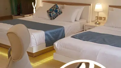 a hotel room with two beds and a chair at Jbr penthouse with terrace pool in Dubai