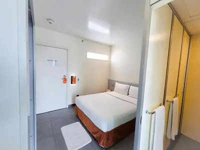 a bedroom with a bed and a door to a bathroom at JOIN INN HOTEL Jebel Ali, Dubai - Formerly easyHotel Jebel Ali in Dubai