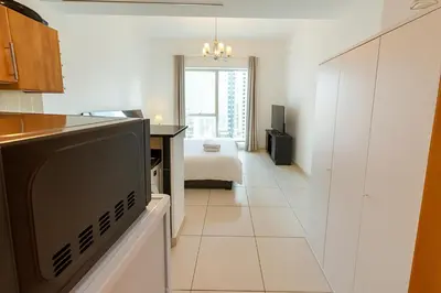 a kitchen with a flat screen tv in a room at Deluxe Studio for Rent at Marina View Towers in Dubai