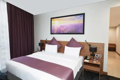 a bedroom with a large white bed with purple pillows at Park Regis Business Bay in Dubai