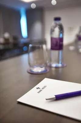 a pen sitting on top of a table with a glass at Park Regis Business Bay in Dubai