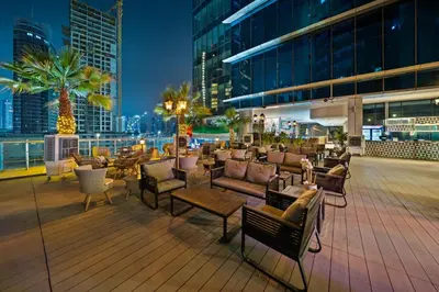 a deck with chairs and tables on a building at Park Regis Business Bay in Dubai